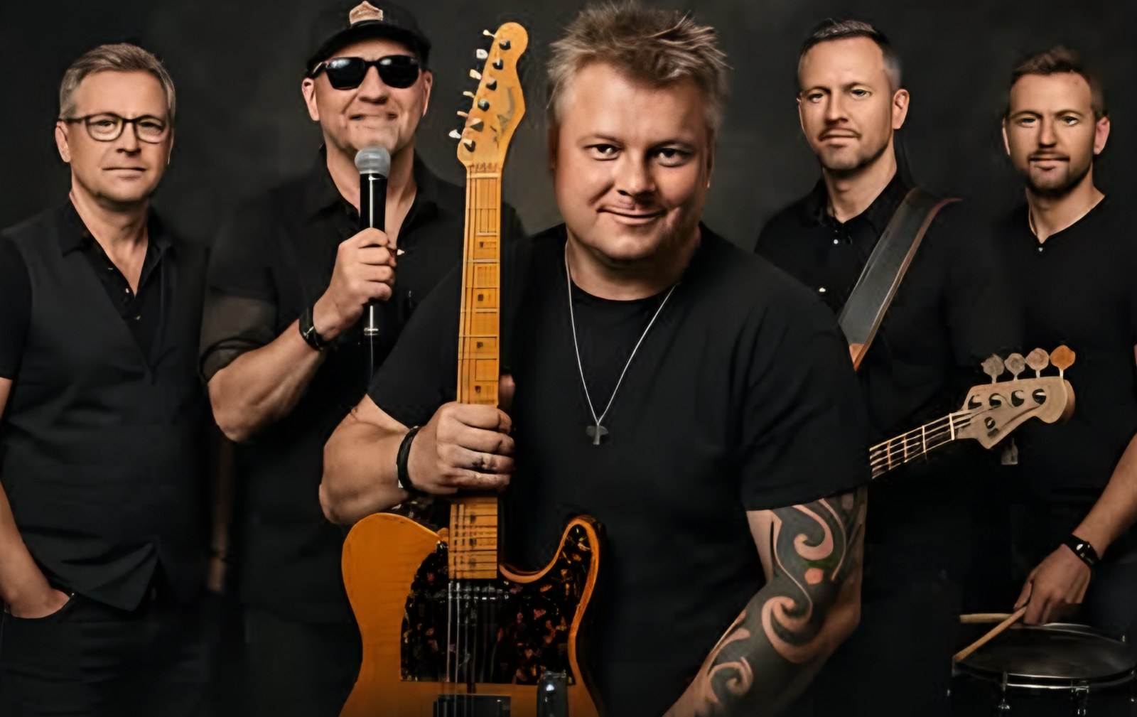 Bandet Mellem-Os med guitarer, mikrofon og trommestikker